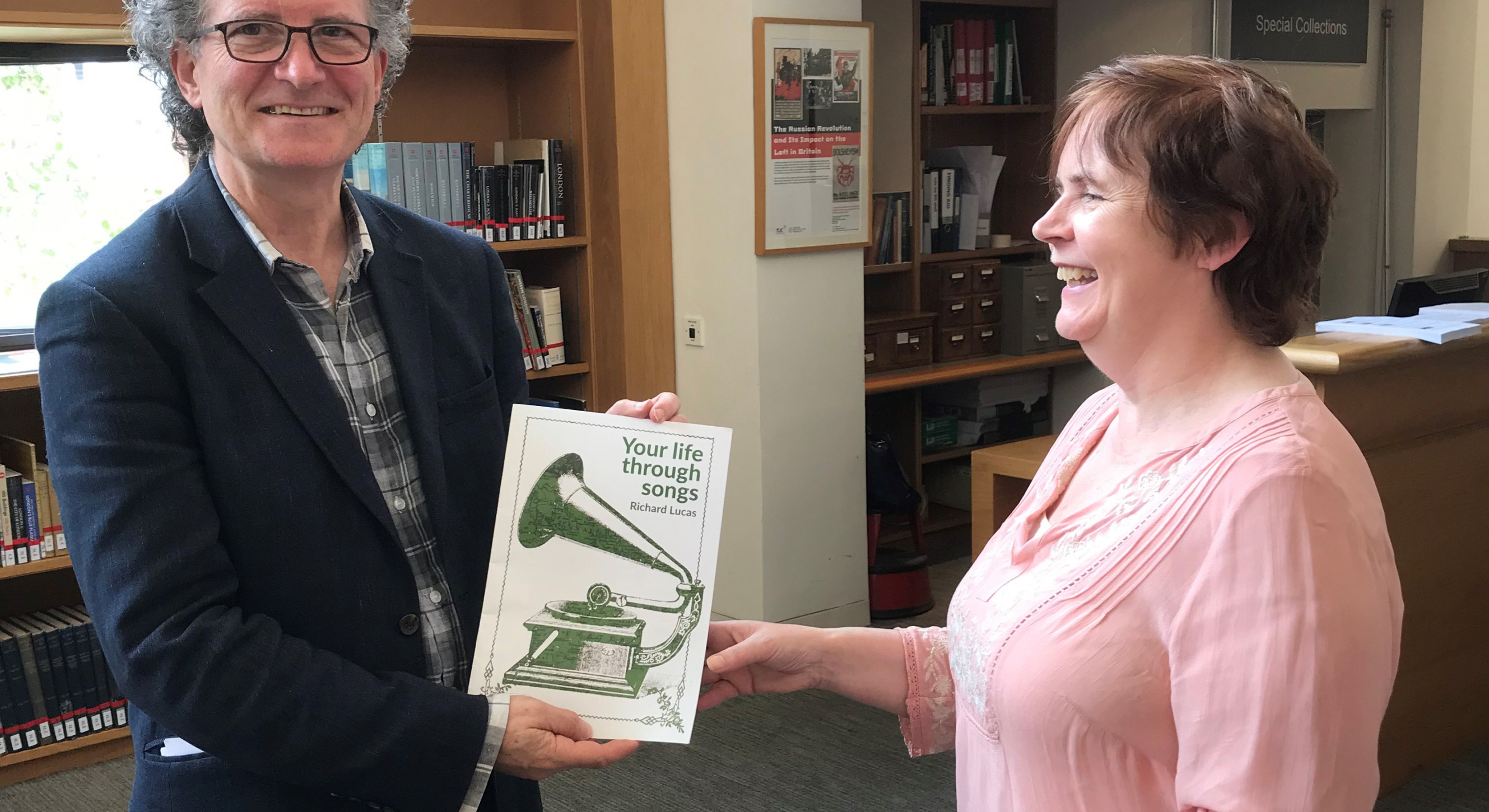 Cuimhne Champion Caroline handing a copy of fellow Champion Richard Lucas's Your Life Through Songs to Tony Murray for the collection.